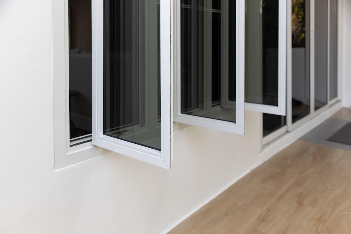 Clean, open tinted house windows with white frames in a modern home.